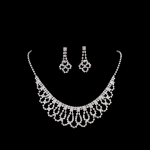 Elegant bridal necklace and earrings set with silver-tone rhinestones on black background