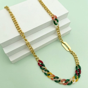 Dettaglio della collana a catena dorata con inserti geometrici in acrilico colorato