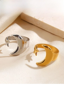 Detailed close-up of polished gold and silver moon star rings on a beige silk surface