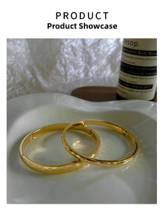 Detail of 18k gold plated stainless steel bangles with textured diamond cut finish