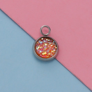 Detailed macro view of a 12mm stainless steel pendant with orange sequins and resin finish