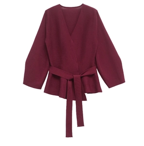 Close-up of wine red wrap knit cardigan with waist belt and elegant flared hem