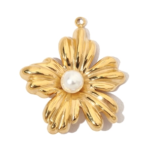 Detailed close-up of a gold floral pendant featuring a white pearl center and five petals
