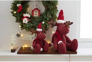 Close-up of red and black checkered Christmas reindeer plush dolls with warm holiday decor