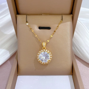 Detail of round cubic zirconia pendant on titanium steel chain in beige jewelry box