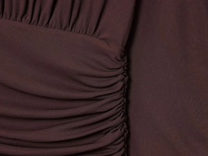 Close-up of ruched coffee brown V-neck dress showing fine knit texture and pleated fabric
