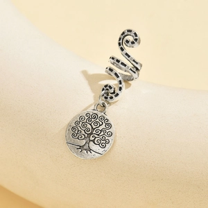 Detailed macro view of silver tree of life pendant and textured spiral hair ring accessory