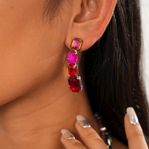Macro view of long drop earrings featuring gradient colorful crystals in silver claw settings