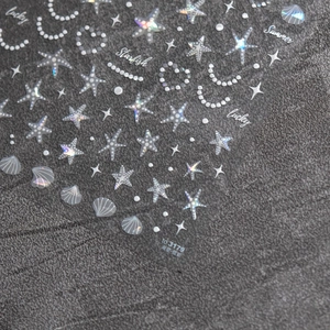 Macro detail of seashell and starfish holographic nail art stickers with iridescent finish