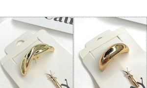 Macro detail of glossy gold metal hair cuff clips with a high-polished finish