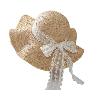 Cappello di paglia in rafia con fiocco in pizzo bianco e tesa ondulata mare