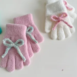 Detailed view of plush knitted kids gloves with soft mohair texture and cute bow tie accents