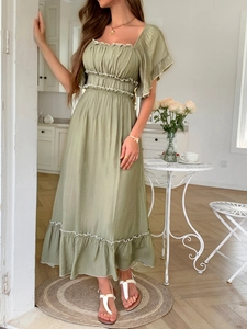 Détail d'une robe midi verte avec col carré, manches à volants et finitions en dentelle blanche