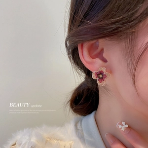 Red beaded flower earrings with gold wire detail on a female model profile view
