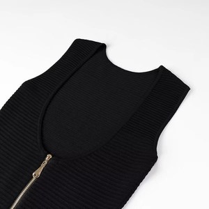 Détail d'une robe noire en maille côtelée avec fermeture éclair dorée et col en U élégant