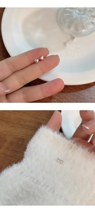 Macro detail of mini S925 sterling silver heart stud earrings with polished finish