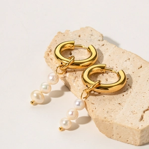 Detail of 18K gold hoop earring featuring three vertically aligned freshwater pearls
