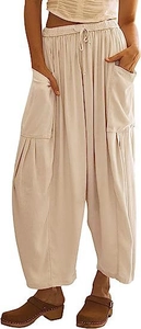 Detailed view of elastic drawstring waist and large side pockets on beige wide leg trousers