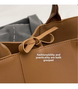 Detailed macro view of litchi textured brown leather tote with bow tie drawstring closure