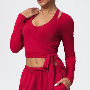 Detail of red wrap-around yoga top with waist tie and matching drawstring gym leggings