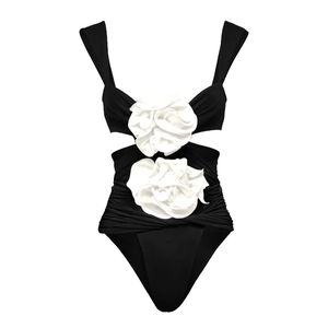 Detail of 3D white camellia flowers and cut-out design on black one-piece swimsuit