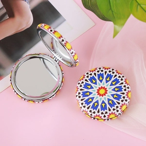 Macro shot of circular folding makeup mirrors with colorful geometric bohemian patterns