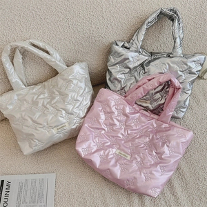 Detailed close-up of quilted heart lunch bags in silver, pearl white and pink colors