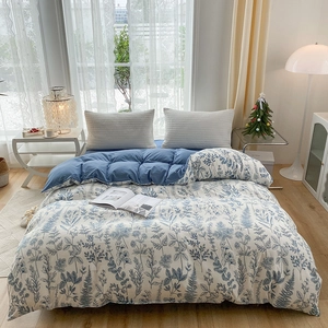 Blue floral print duvet cover set with light grey pillowcases in a cozy bedroom setting
