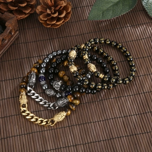 Detailed macro shot of tiger eye beads, obsidian stones with gold mantra, and buddha head charm