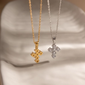 Dettaglio dei ciondoli a croce in zircone oro e argento con raffinato design posteriore