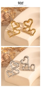 Detailed view of layered hollow heart-shaped earrings in polished gold and silver metal finishes