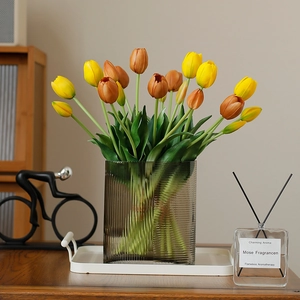 5-piece bunch of realistic soft rubber tulips in yellow and orange in a grey glass vase