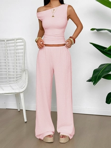 Detail view of pink two-piece set featuring pleated texture and one-shoulder sleeveless top