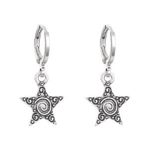 Detail of silver hoop earrings featuring vintage star pendants and spiral carvings
