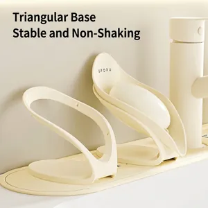 Minimalist leaf-shaped self-draining soap holder with cream finish on a bathroom sink