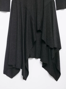 Vue détaillée de la robe en maille gris foncé avec un ourlet ondulé asymétrique unique