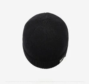 Draufsicht auf die schwarze Rippenstrickmütze mit weißem Seitenlogo-Detail für den Winter