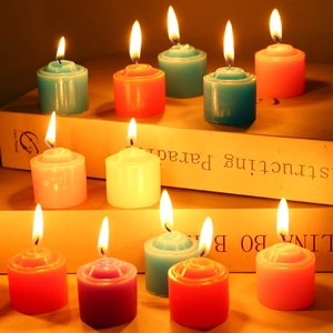 Close-up of burning colorful tea light candles on books for a warm home atmosphere
