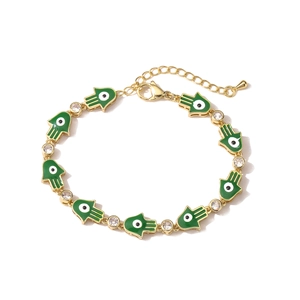 Detail of gold Hamsa Hand charms with green enamel and evil eye inlays on a bracelet