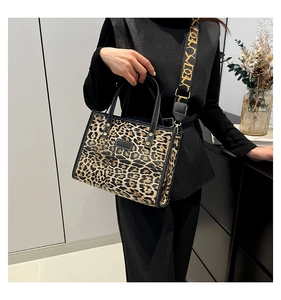 Detail of vintage leopard print tote bag with wide patterned strap and leather trim