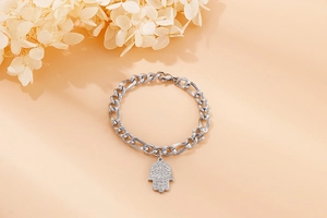Dettaglio del bracciale con ciondolo mano di Fatima in acciaio al titanio e catena groumette