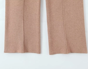 Close-up of camel knitted pants featuring detailed hem texture and decorative center seam