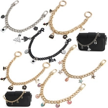Detailed view of gold and silver purse chain extensions with various decorative charms