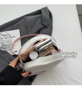 Spacious interior of white leather skull crossbody bag showing multi-compartment storage