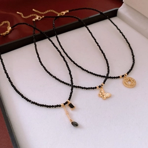 Three gold plated black bead necklaces with butterfly and geometric heart pendants
