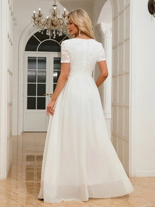 Detailed lace texture and pleated chiffon fabric on an elegant white evening gown