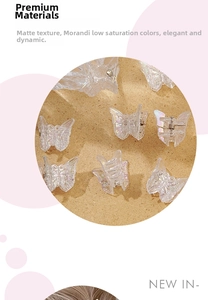 Macro shot of laser translucent butterfly hair claw clips on elegant sand texture