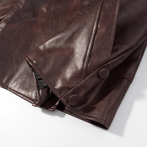 Vue détaillée de la manche de veste en cuir marron foncé avec boutons décoratifs
