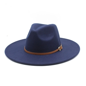 Detail of navy blue wool fedora hat featuring a brown leather band and gold buckle
