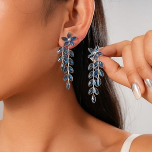 Detailed close-up of blue crystal leaf tassel earrings on a model for a vintage look